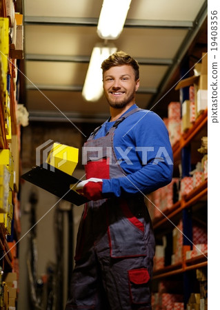 Worker on a automotive spare parts warehouse 19408356