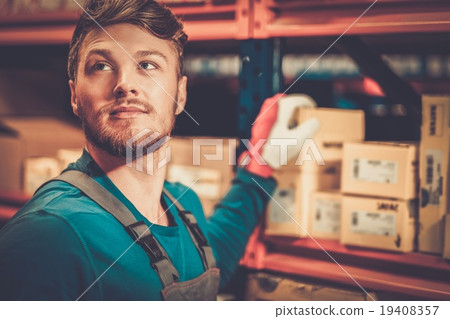Worker on a automotive spare parts warehouse 19408357