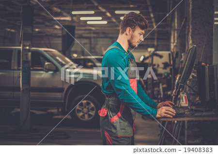 Specialist near car diagnostic pc in a workshop Specialist near car diagnostic pc in a workshop 19408383