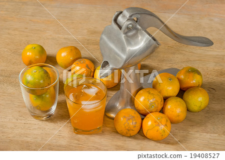 Glass of orange juice and Juicer on wooden table Glass of orange juice and Juicer on wooden table 19408527