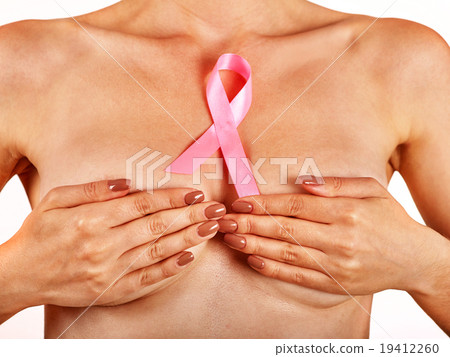 Pink badge on woman hand to support breast cancer 19412260
