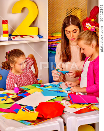 Kids holding colored paper on table in Kids holding colored paper on table in 19412341