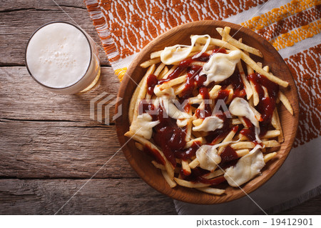 poutine and beer close-up. horizontal top view 19412901