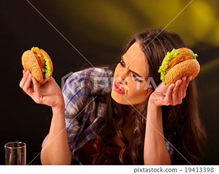 Girl eating big sandwich. 19413398