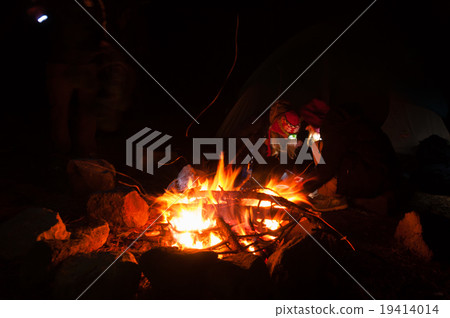 Hikers Gathered Around a campfire at night with 19414014