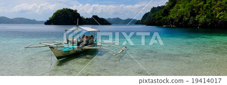 Traditional wooden filipino boat in a blue lagoon Traditional wooden filipino boat in a blue lagoon 19414017