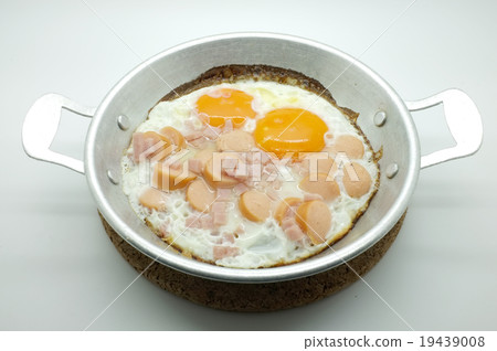 Fried egg with ham and sausage in a pan Fried egg with ham and sausage in a pan 19439008
