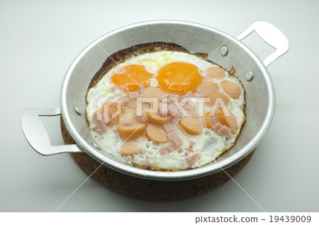 Fried egg with ham and sausage in a pan Fried egg with ham and sausage in a pan 19439009