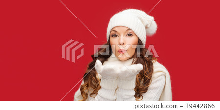 happy woman in winter clothes blowing on palms 19442866