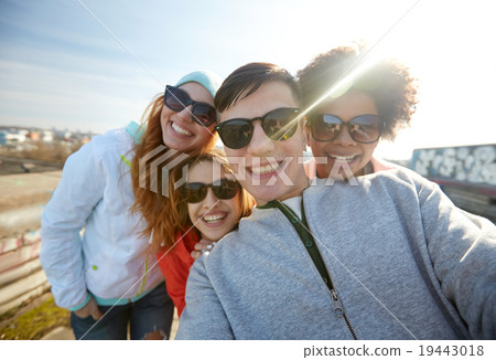 group of happy friends taking selfie on street 19443018