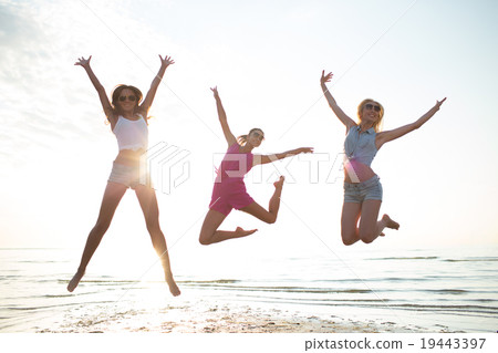 happy female friends dancing and jumping on beach happy female friends dancing and jumping on beach 19443397