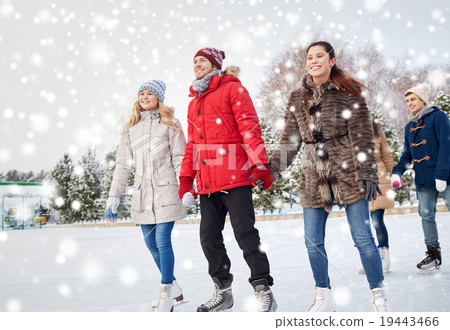 happy friends ice skating on rink outdoors 19443466