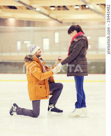 happy couple with engagement ring on skating rink 19443482