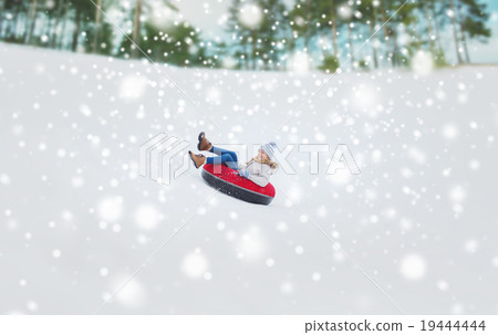 happy teenage girl sliding down on snow tube happy teenage girl sliding down on snow tube 19444444