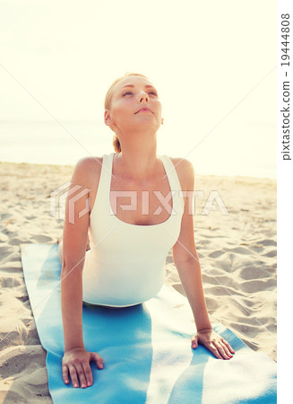 young woman making yoga exercises outdoors 19444808