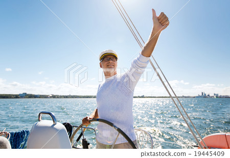 senior man at helm on boat or yacht sailing in sea senior man at helm on boat or yacht sailing in sea 19445409
