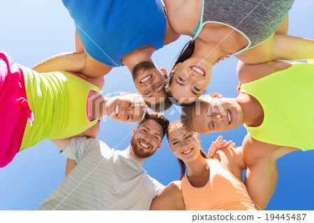 group of happy sporty friends in circle outdoors 19445487