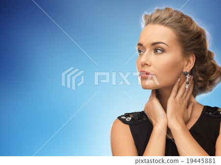 beautiful woman wearing earrings over blue beautiful woman wearing earrings over blue 19445881
