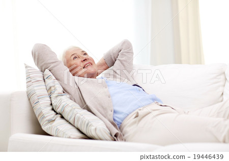 happy senior woman resting on sofa at home happy senior woman resting on sofa at home 19446439