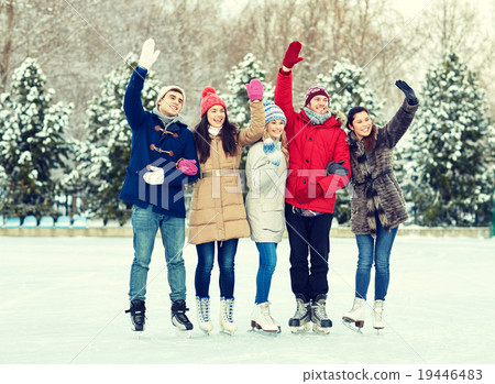 happy friends ice skating on rink outdoors 19446483