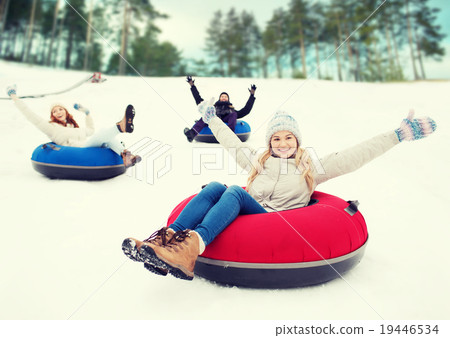group of happy friends sliding down on snow tubes group of happy friends sliding down on snow tubes 19446534
