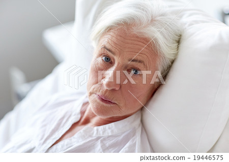 senior woman patient lying in bed at hospital ward 19446575