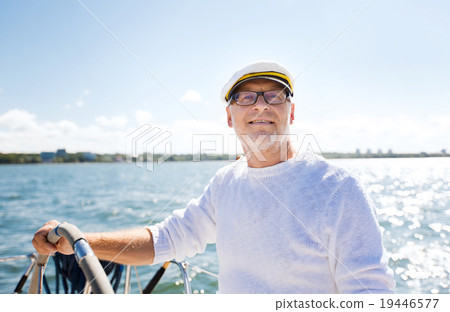 senior man at helm on boat or yacht sailing in sea senior man at helm on boat or yacht sailing in sea 19446577