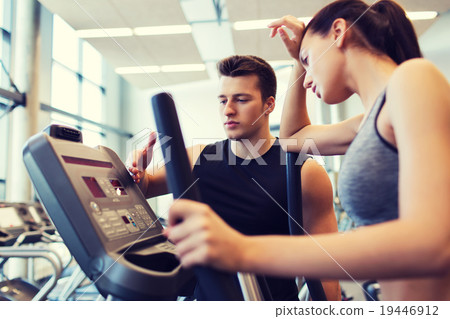 woman with trainer exercising on stepper in gym 19446912