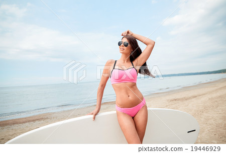smiling young woman with surfboard on beach 19446929