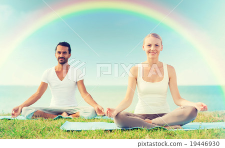smiling couple making yoga exercises outdoors 19446930