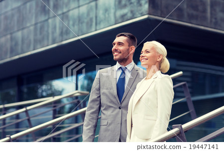 smiling businessmen standing over office building 19447141