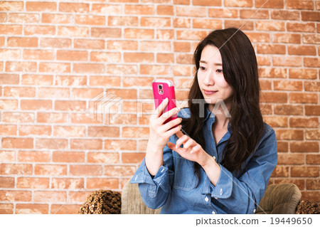 Woman holding a smartphone Woman holding a smartphone 19449650