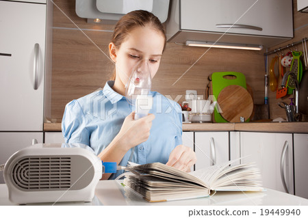 Girl doing inhalation and reading book 19449940