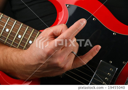 Hand with red guitar and devil horns on black 19455040