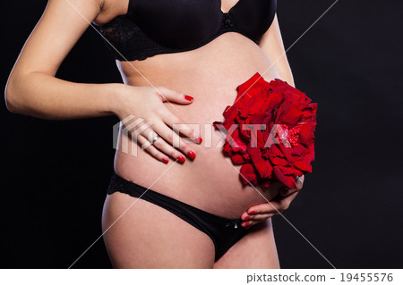 Red rose flower on woman's pregnant belly 19455576