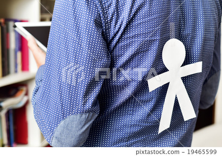 young man with a paper man attached in his back 19465599