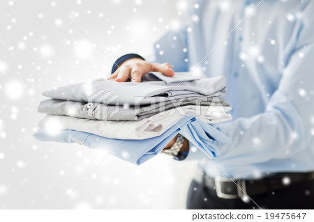 close up of businessman holding folded shirts 19475647