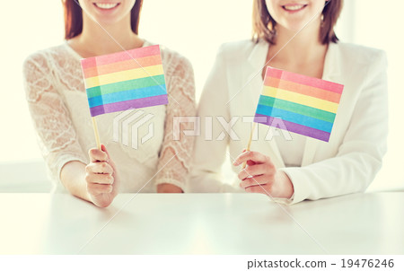 close up of happy lesbian couple with rainbow flag 19476246
