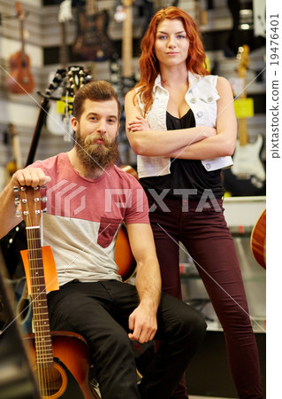 couple of musicians with guitar at music store 19476401