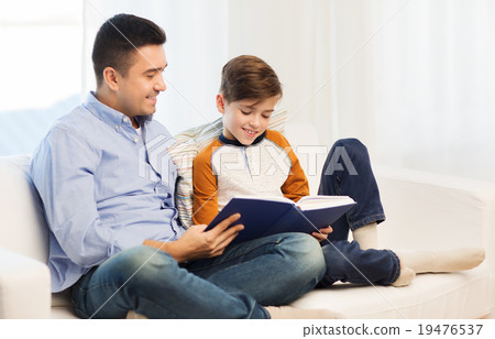 happy father and son reading book at home 19476537