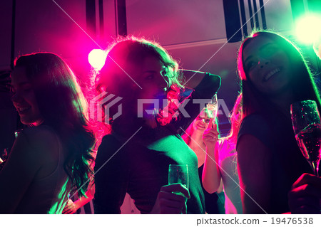 smiling friends with glasses of champagne in club smiling friends with glasses of champagne in club 19476538