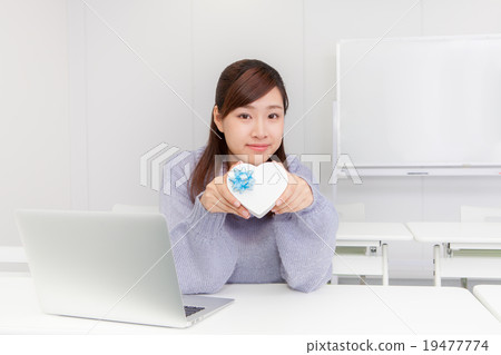 A woman with a heart-shaped gift box A woman with a heart-shaped gift box 19477774