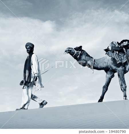 Indigenous Indian man walking desert camel Concept 19480790