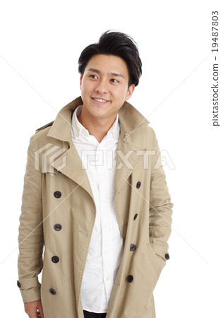 A young man wearing a trench coat 19487803