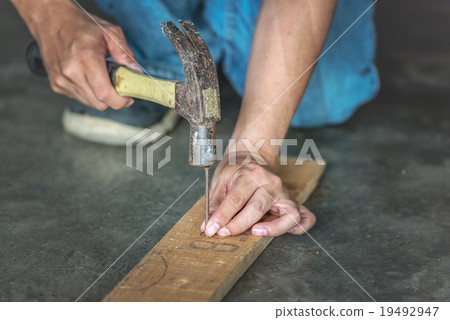 man hands drive nail with a hammer in wooden man hands drive nail with a hammer in wooden 19492947