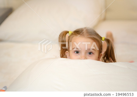 Little girl on the bed at home among the pillows 19496553