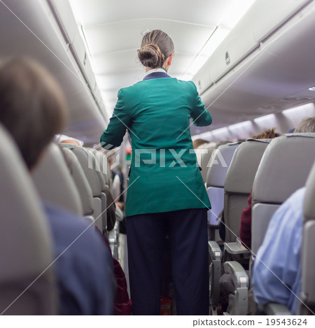 Stewardessand passengers on commercial airplane. 19543624