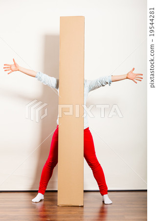 Happy woman moving into apartment carrying box. 19544281