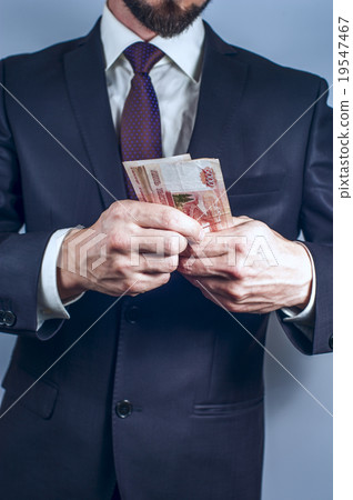 Bearded man in suit holds Russian rubles 19547467