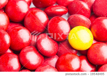 Focus on yellow chocolate candy against red Focus on yellow chocolate candy against red 19548495